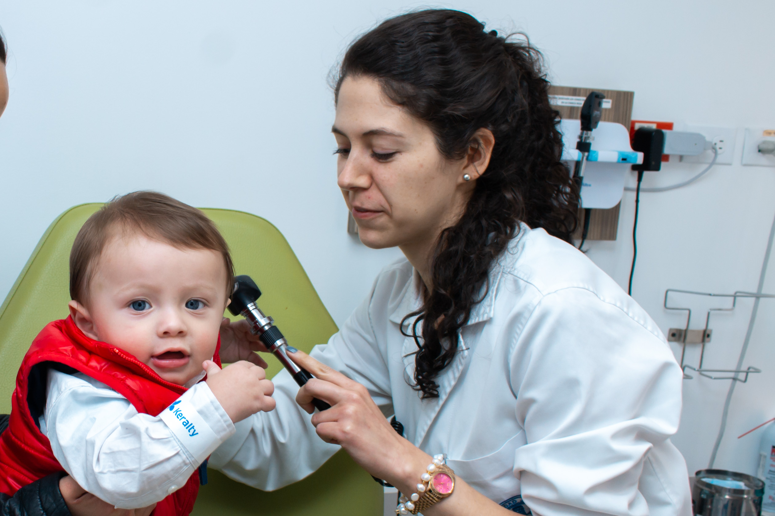 Doctora examinando oído de bebe